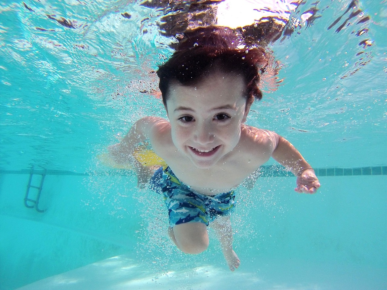 Barn som simmar under vatten.